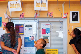 Shalayne Saunders, right, Kane Bennett and Alyssa Kee compete in a donut eating contest during the Fourth of July family carnival at the Thoreau Community Center Monday. &copy; 2011 Gallup Independent / Cable Hoover